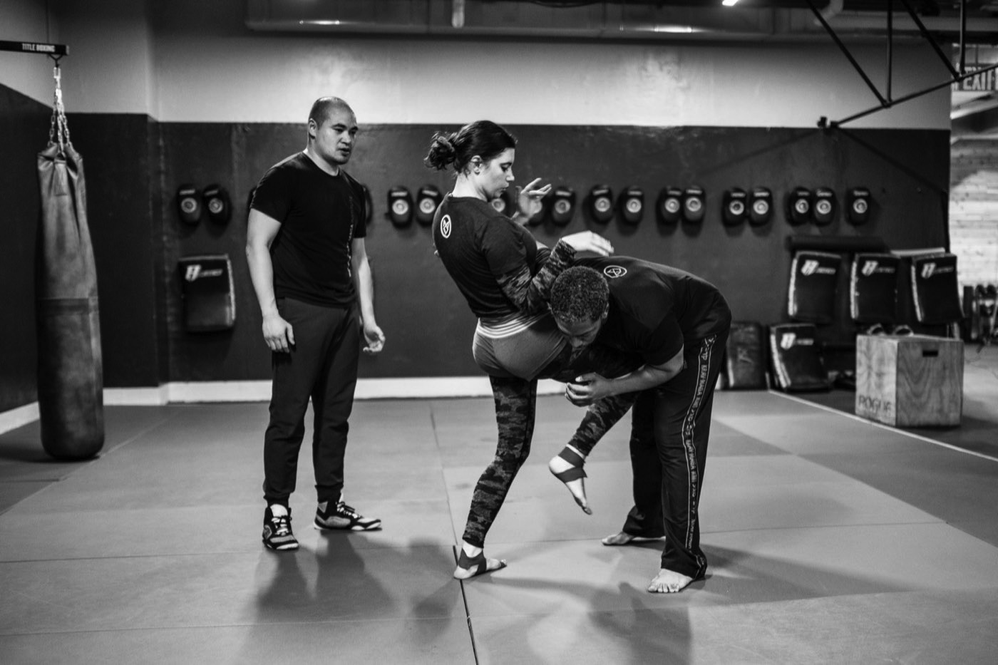 A woman driving a knee strike in a KMI women's self-defense class